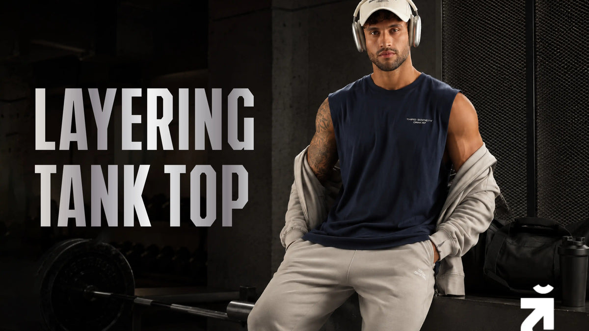 Man wearing the Third Society Lifting Community Iron Blue Tank and Ash Grey Joggers while layering at the gym