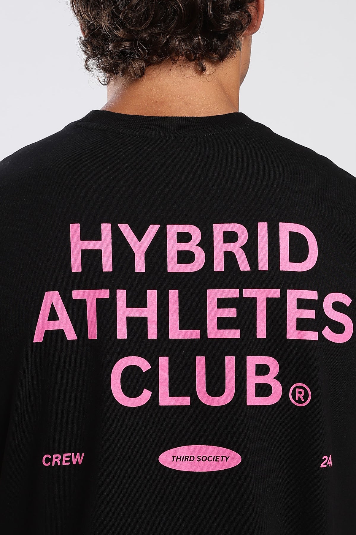 Close-up of the pink Hybrid Athletes Club graphic on the black tank top