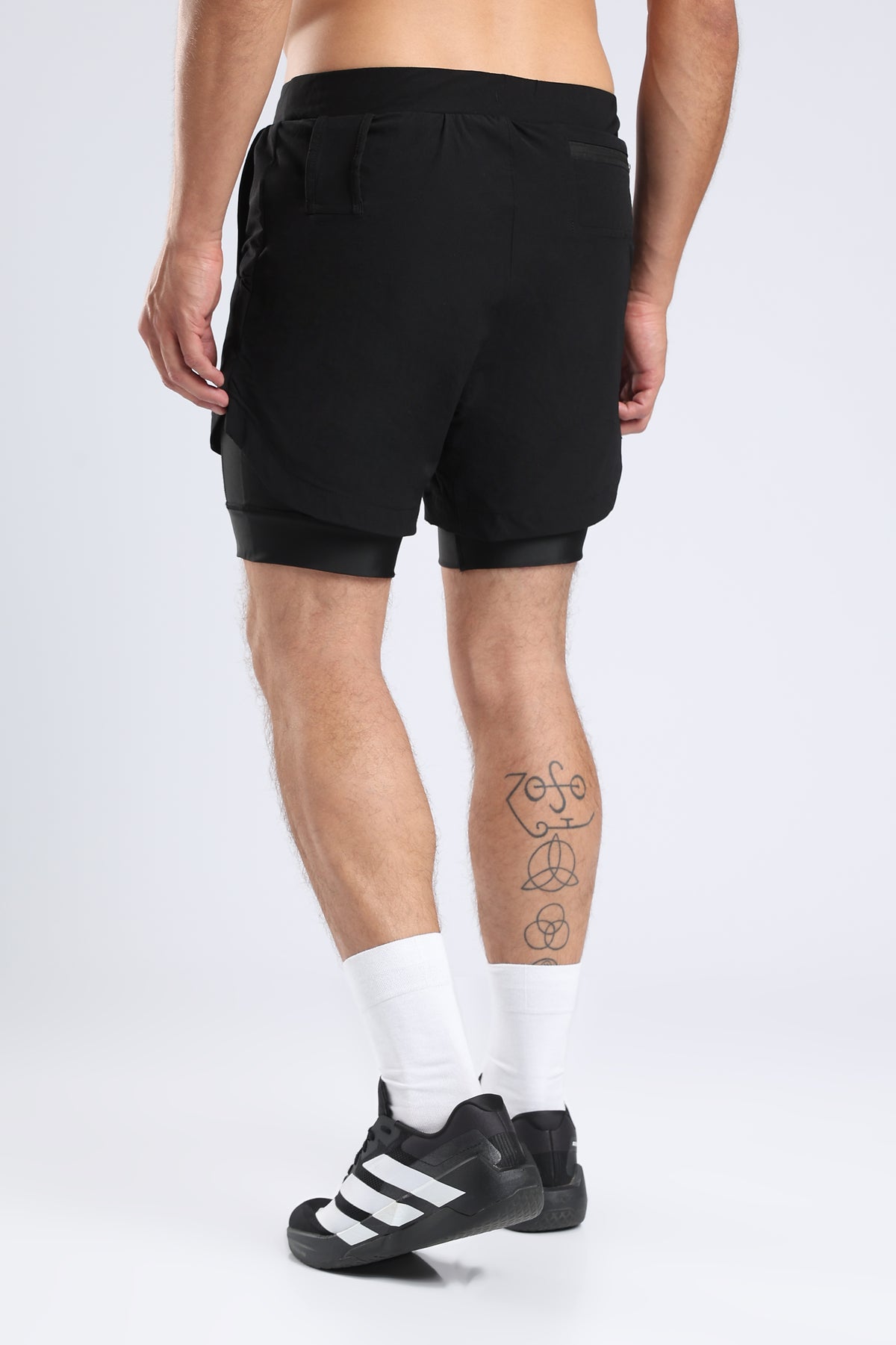 Rear view of a model wearing black hybrid liner shorts with an integrated inner liner