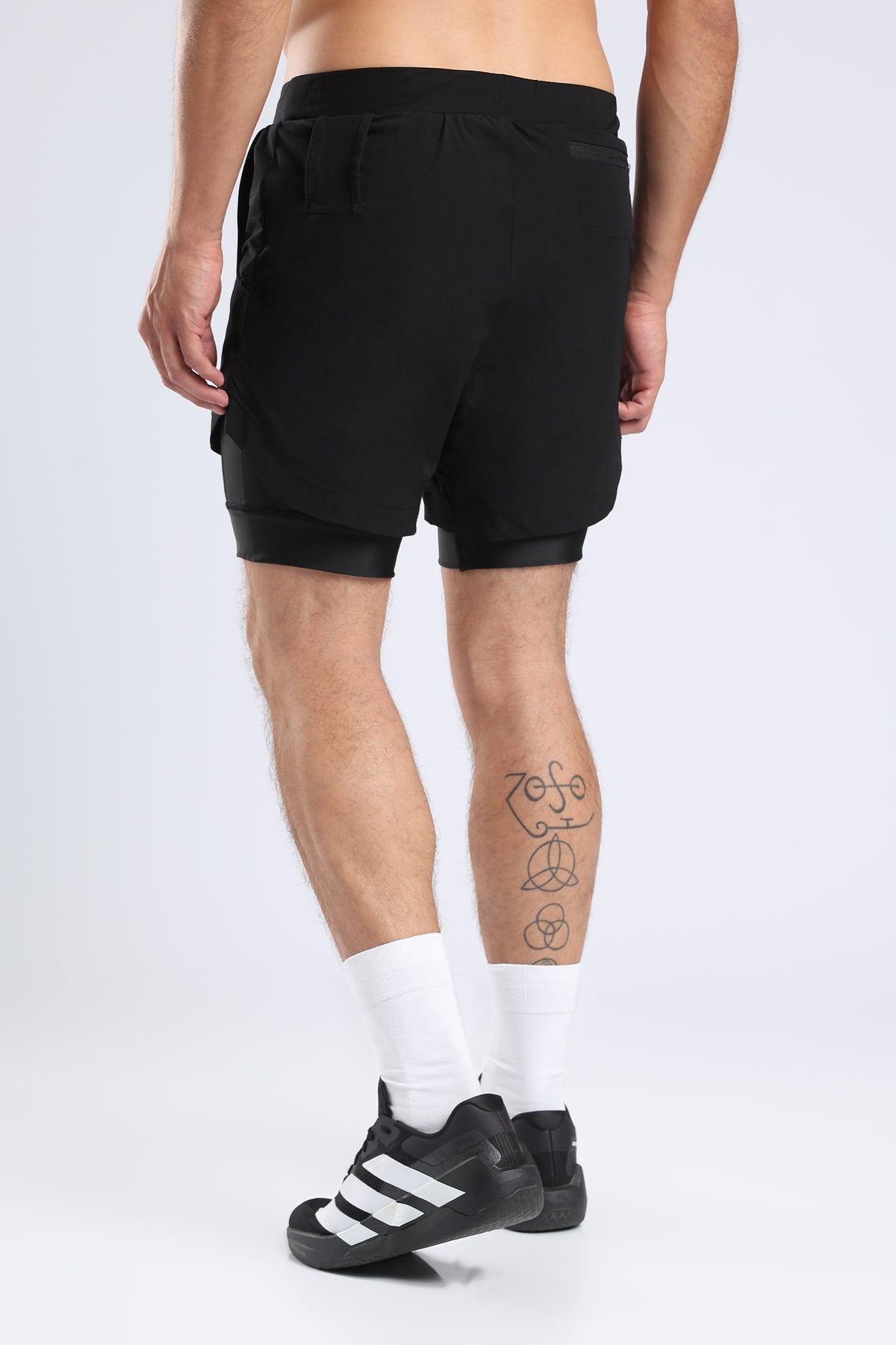 Rear view of a model wearing black hybrid liner shorts with an integrated inner liner