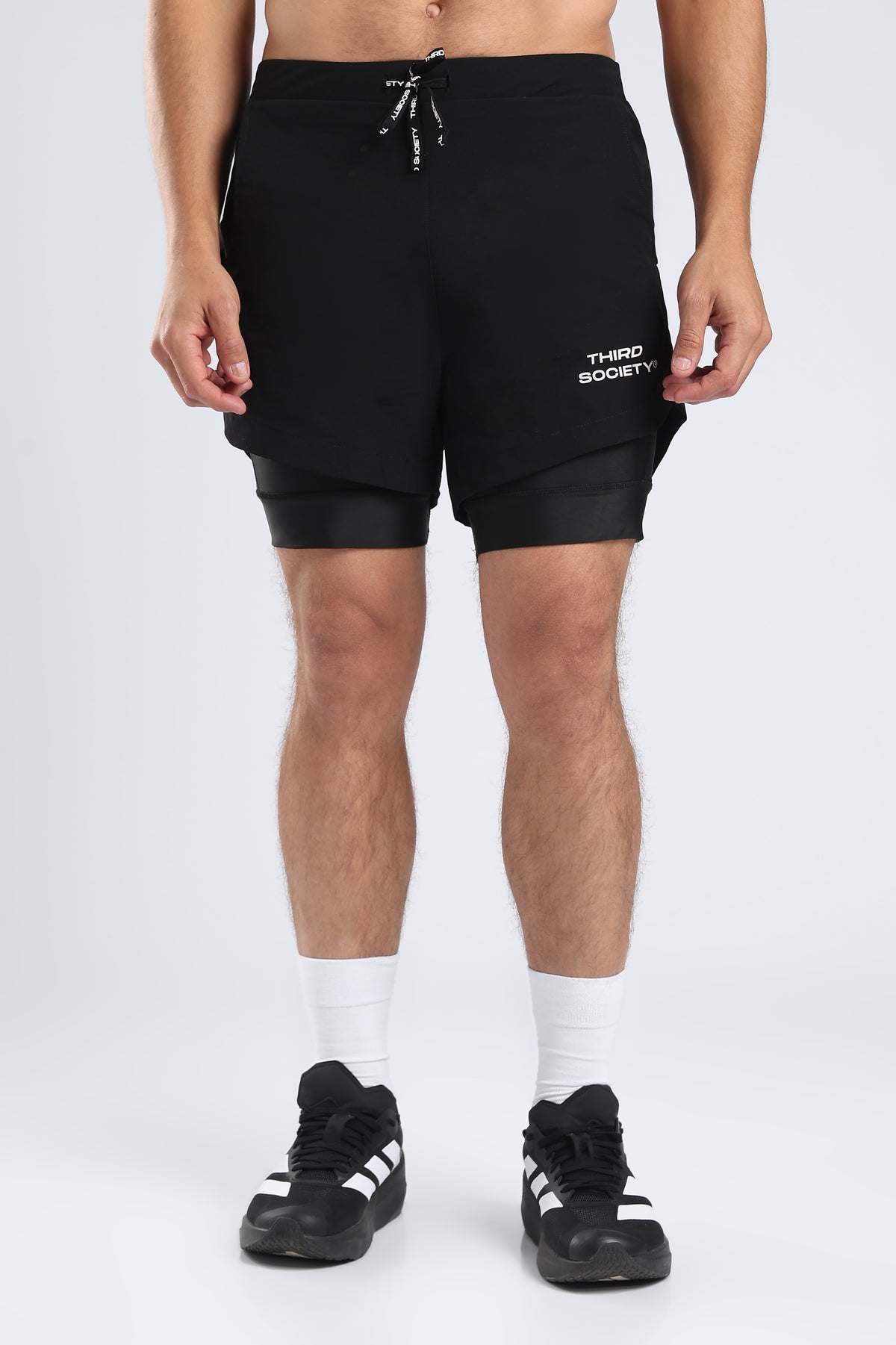 Side view of black hybrid liner shorts with a towel held in the utility loop
