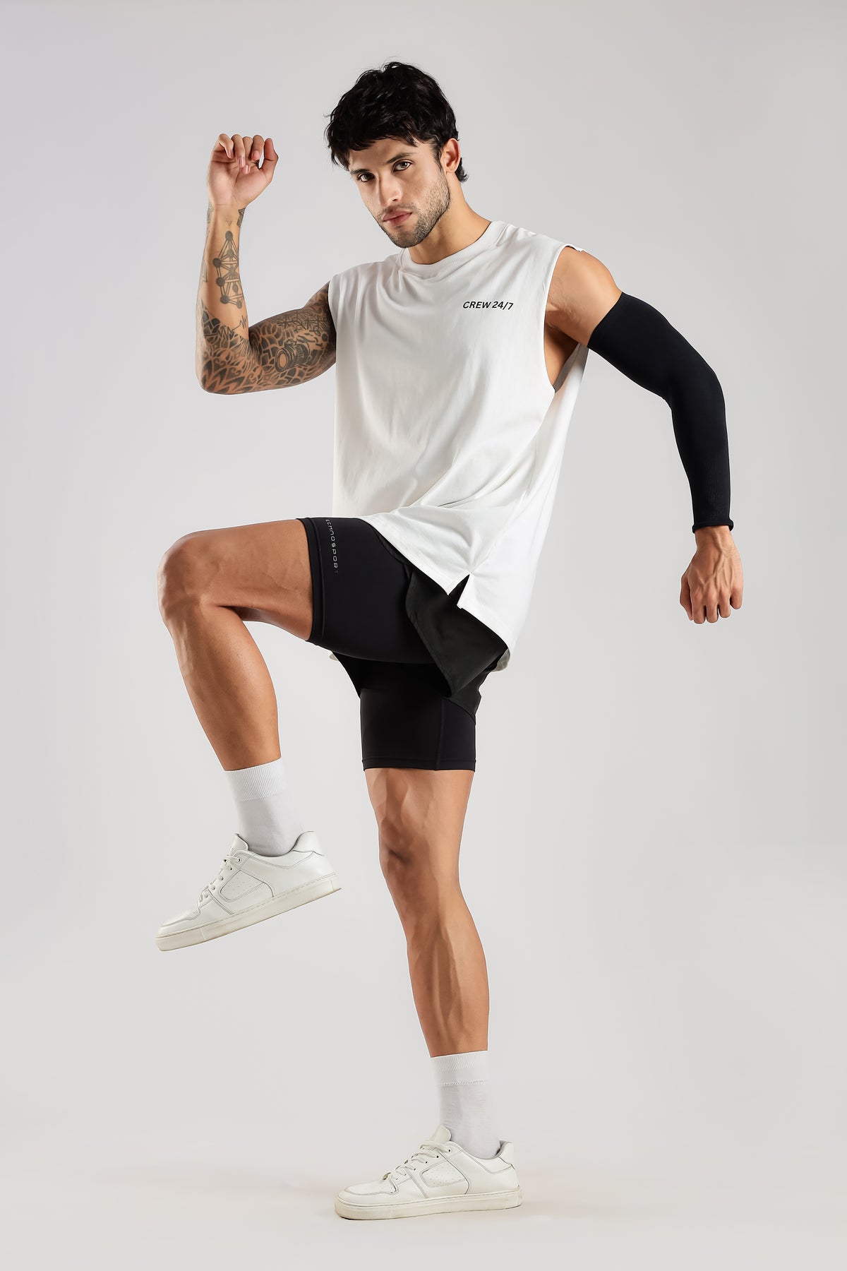 Model wearing the white Push Pull Tank during an active movement pose