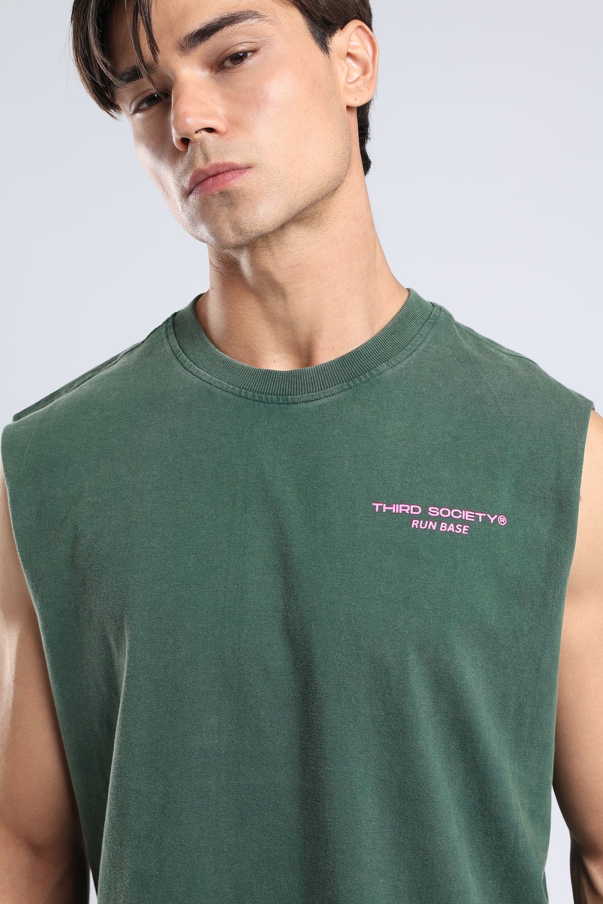 Close-up of the pink Run Base chest logo on the Forest Moss tank