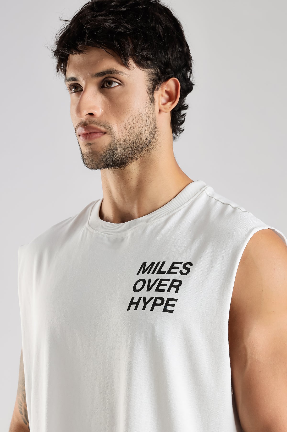 Close-up of the Miles Over Hype graphic on the white tank top
