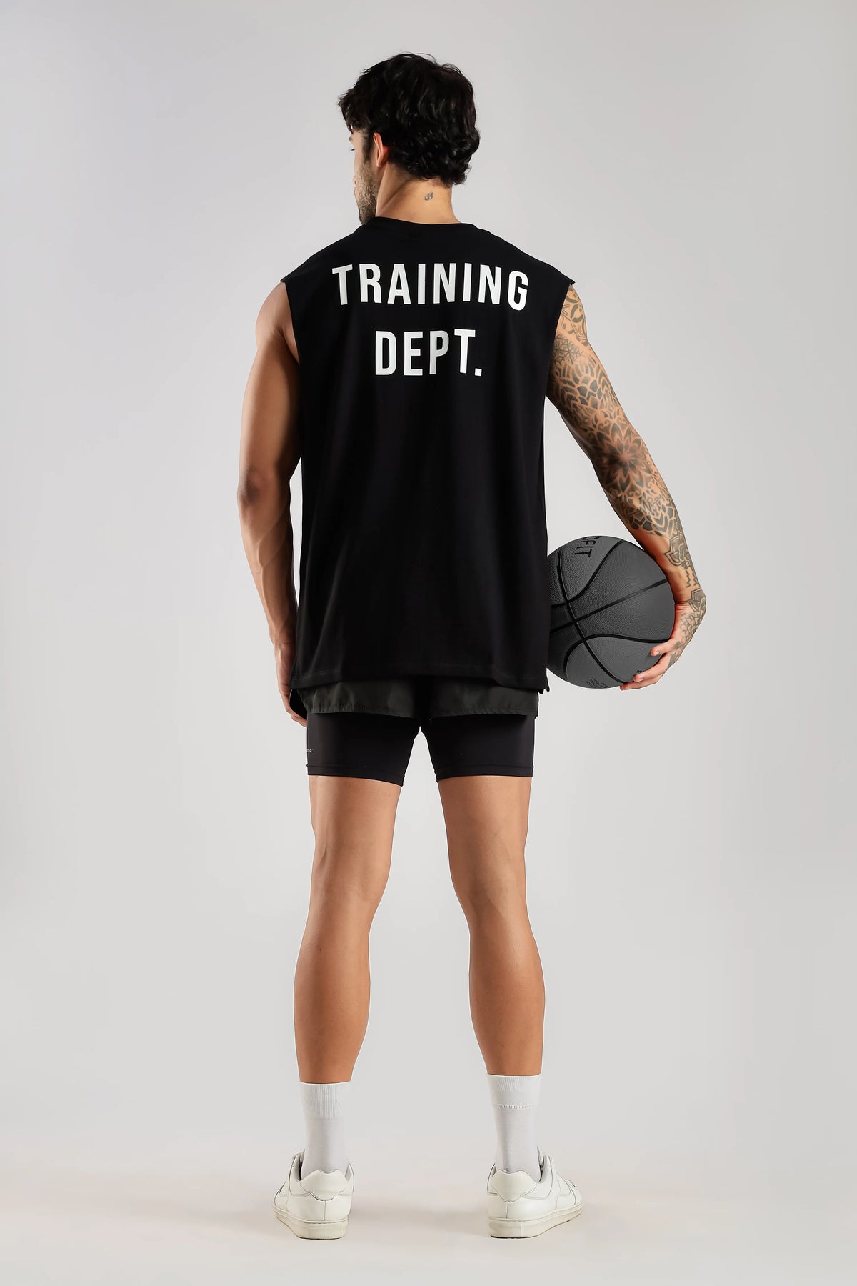 Back view of the black Training Dept tank top styled with a basketball and black shorts