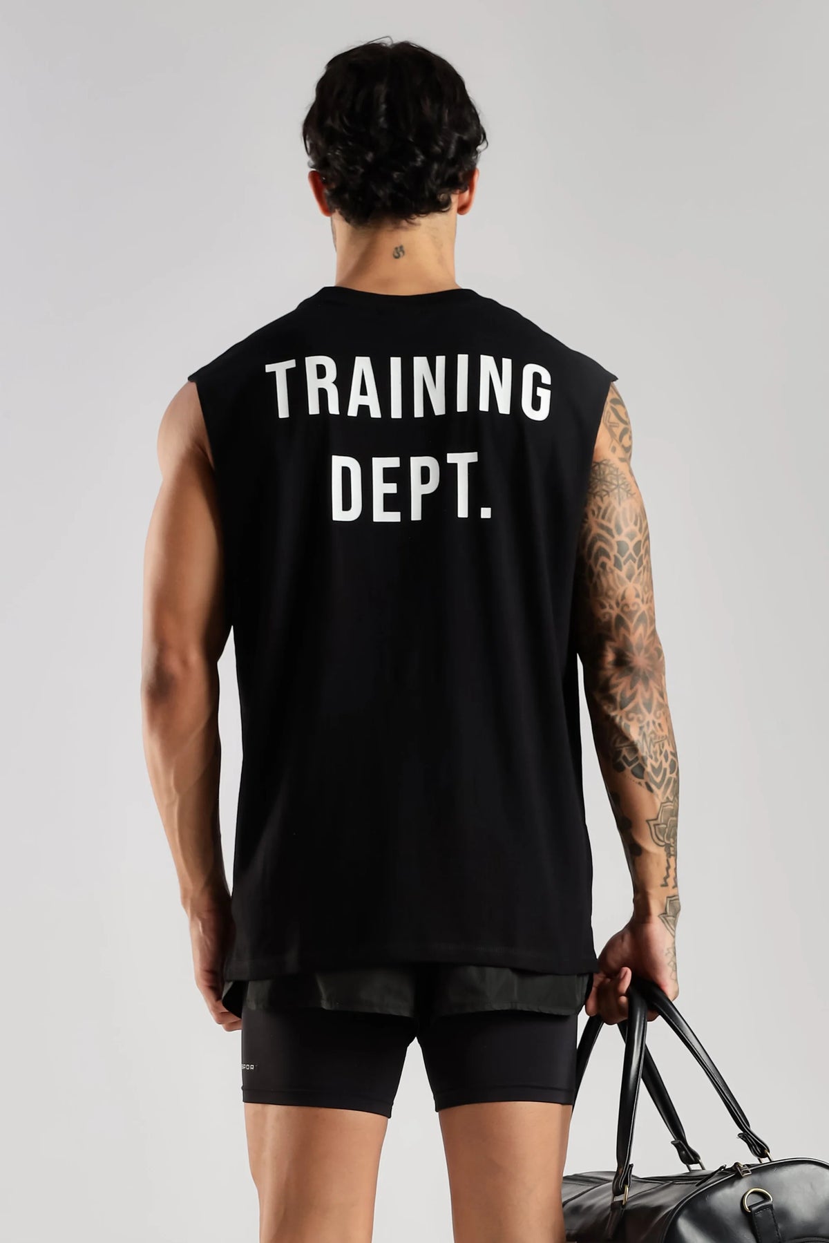 Model wearing the black Training Dept tank top showing the large Training Dept back graphic