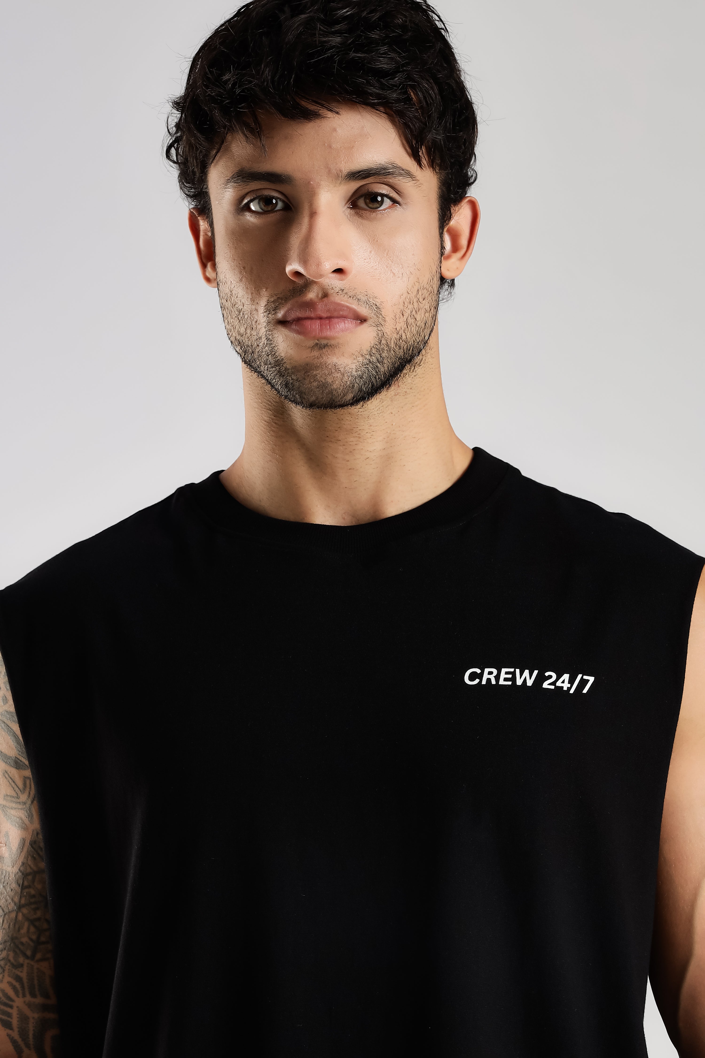 Close-up of the black tank top showing the Crew 24/7 chest branding