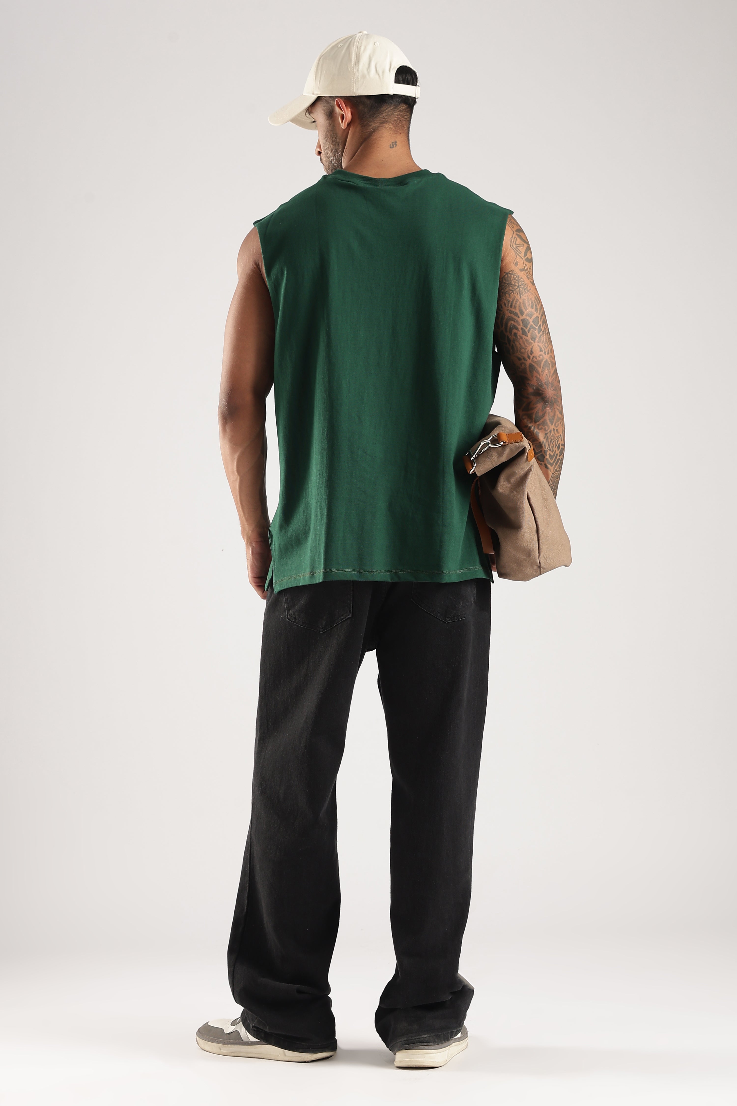 Back view of a model wearing the Forest Green oversized tank top with black trousers