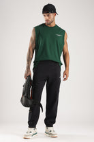 Model wearing the Forest Green Third Society tank top with black joggers and a backpack