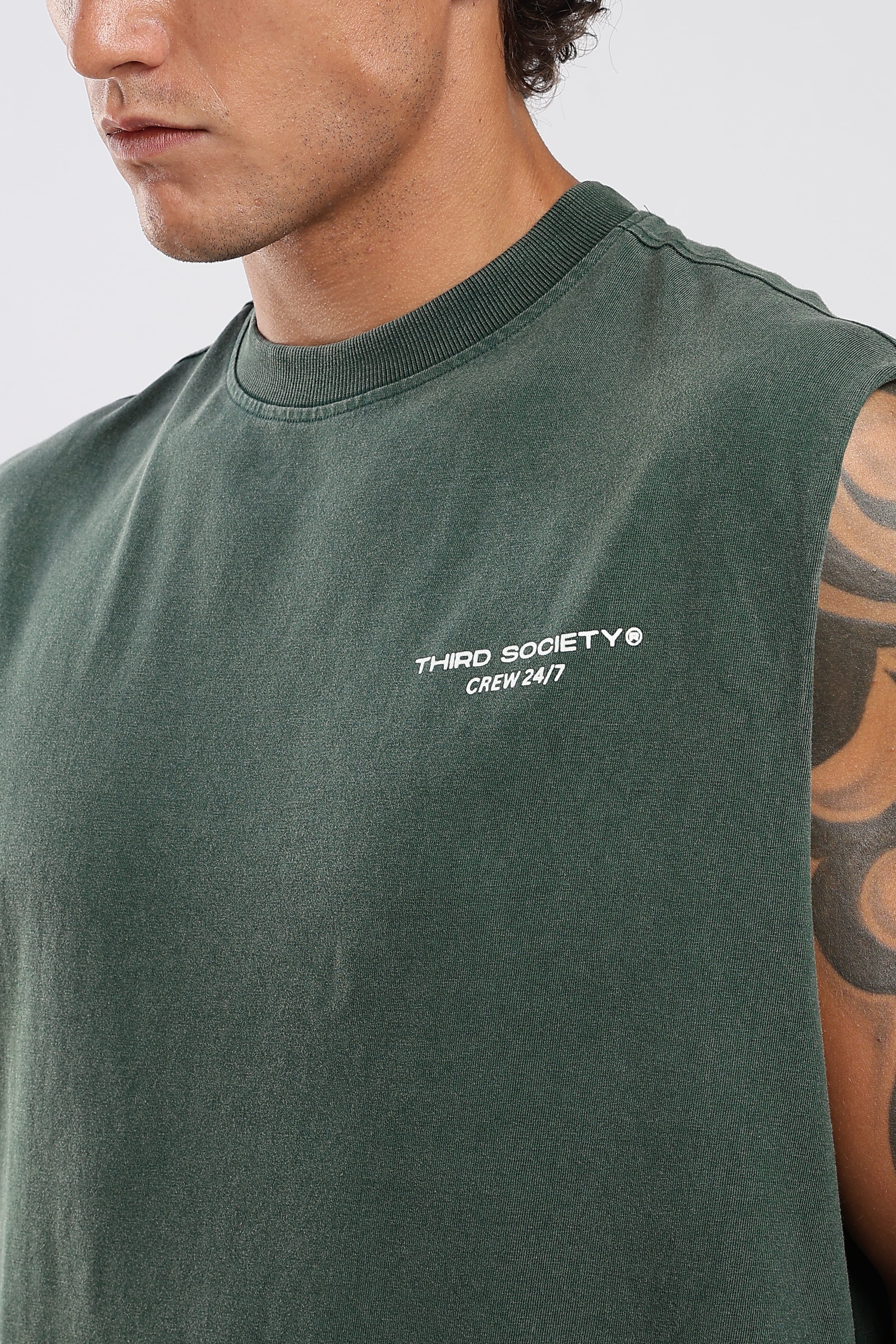 Close-up of Forest Moss tank top showing the Third Society chest logo and ribbed neckline