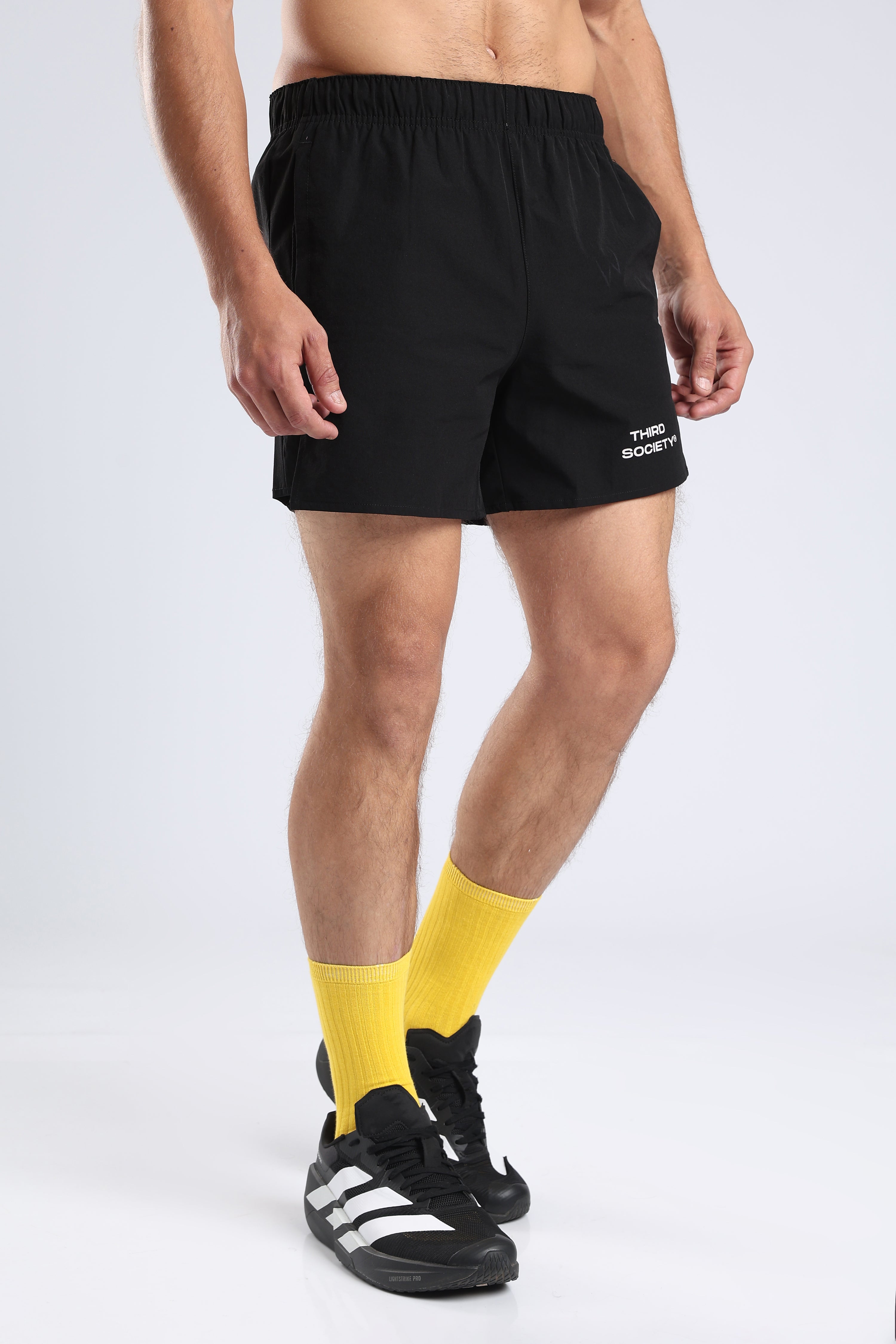 Side view of a model wearing black Hybrid 5-Inch Running Shorts