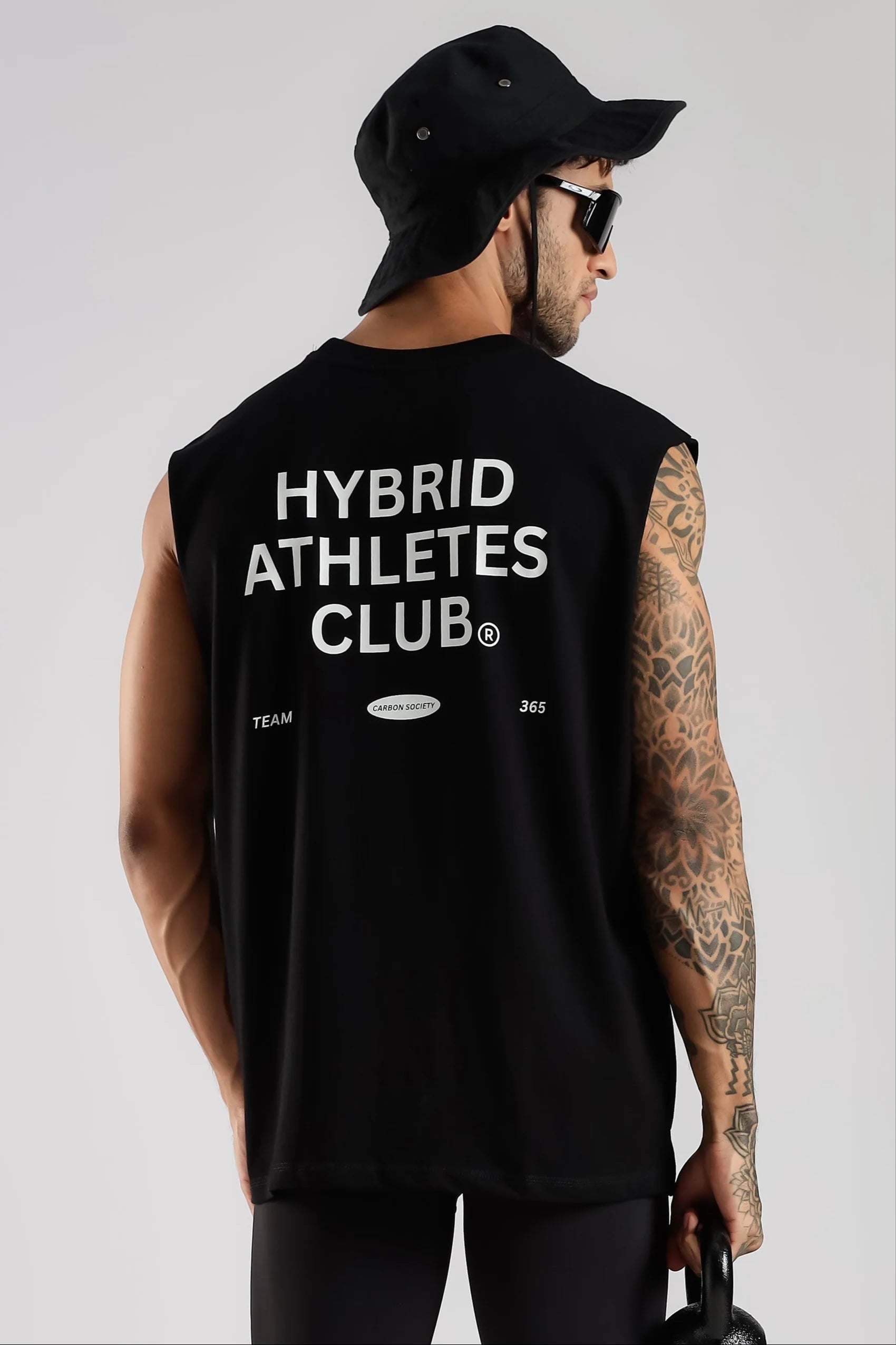 Black sleeveless tank top showing Hybrid Athletes Club back graphic and relaxed fit