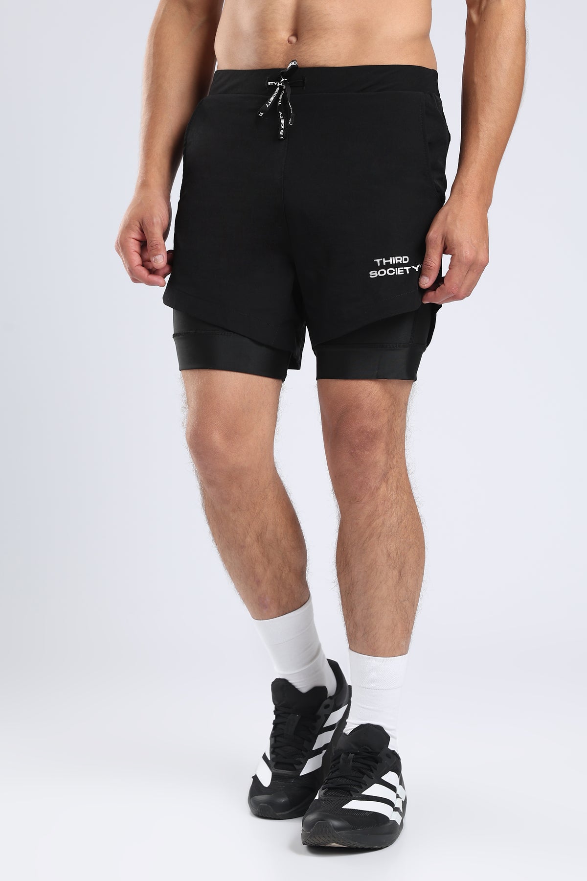 Close-up of black hybrid liner shorts showing the drawstring waistband and logo
