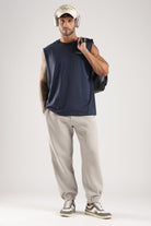 Model wearing the Navy tank top with beige joggers, headphones and a shoulder bag