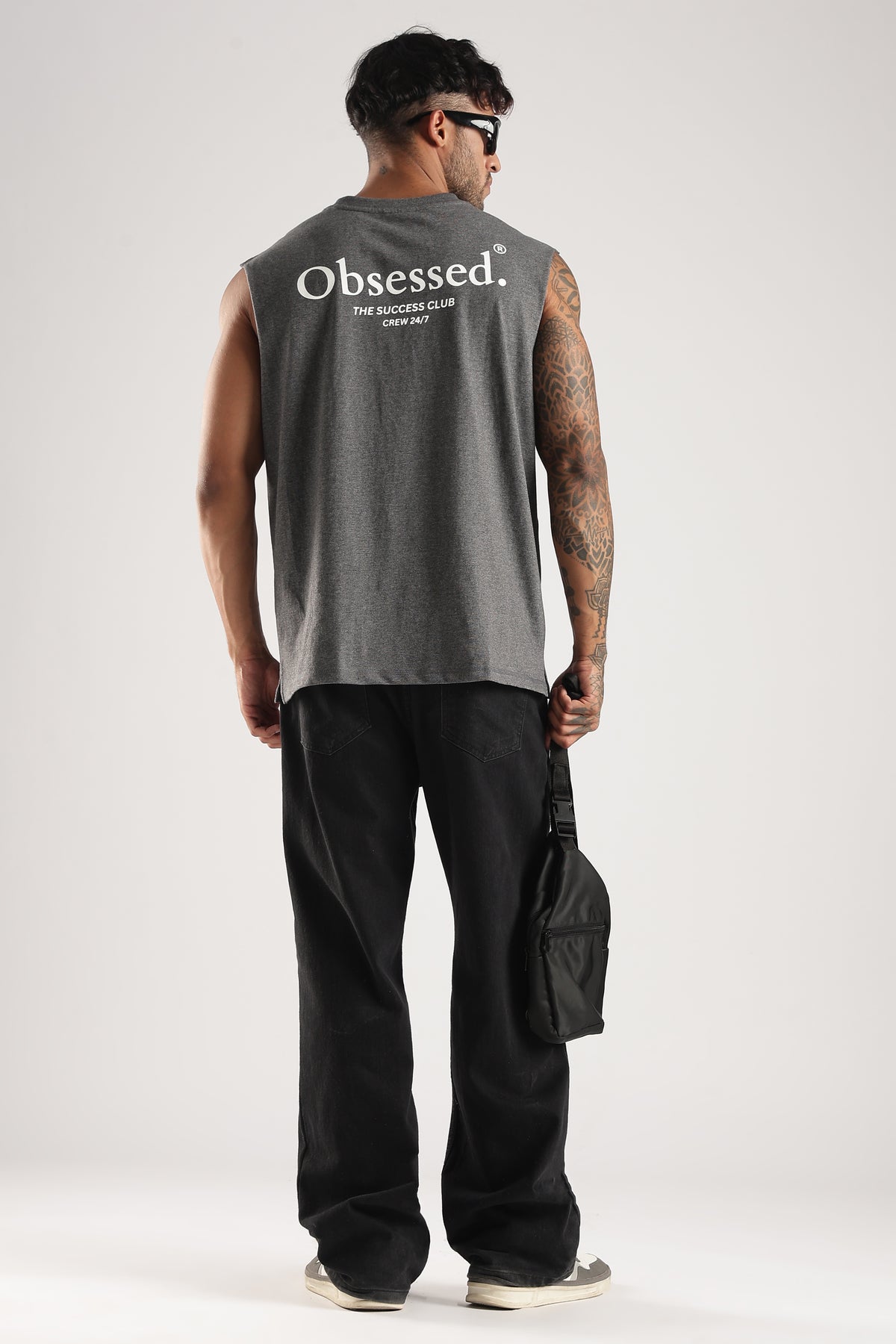 Model wearing the Grey Marl Obsessed Tank from the back with the Success Club graphic and crossbody bag