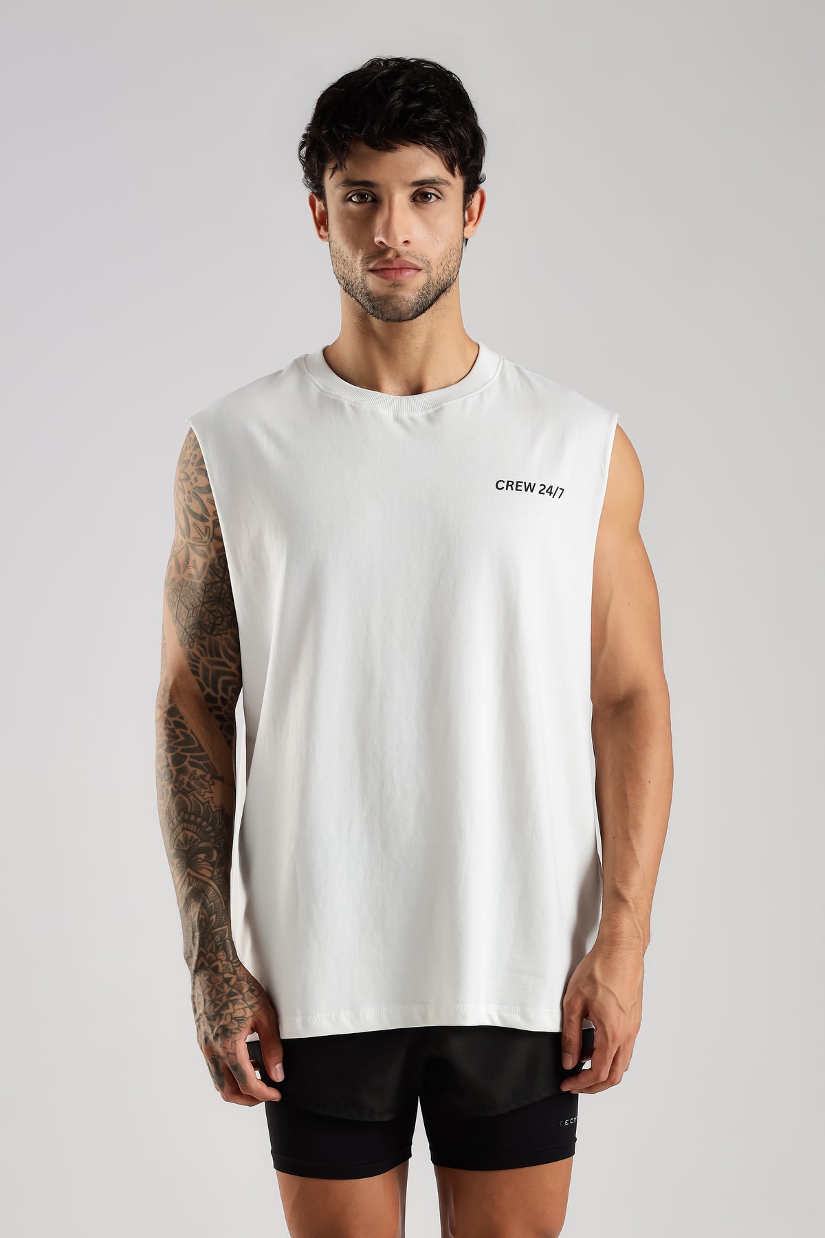 Model wearing the white Push Pull Tank showing the relaxed oversized fit and Crew 24/7 branding
