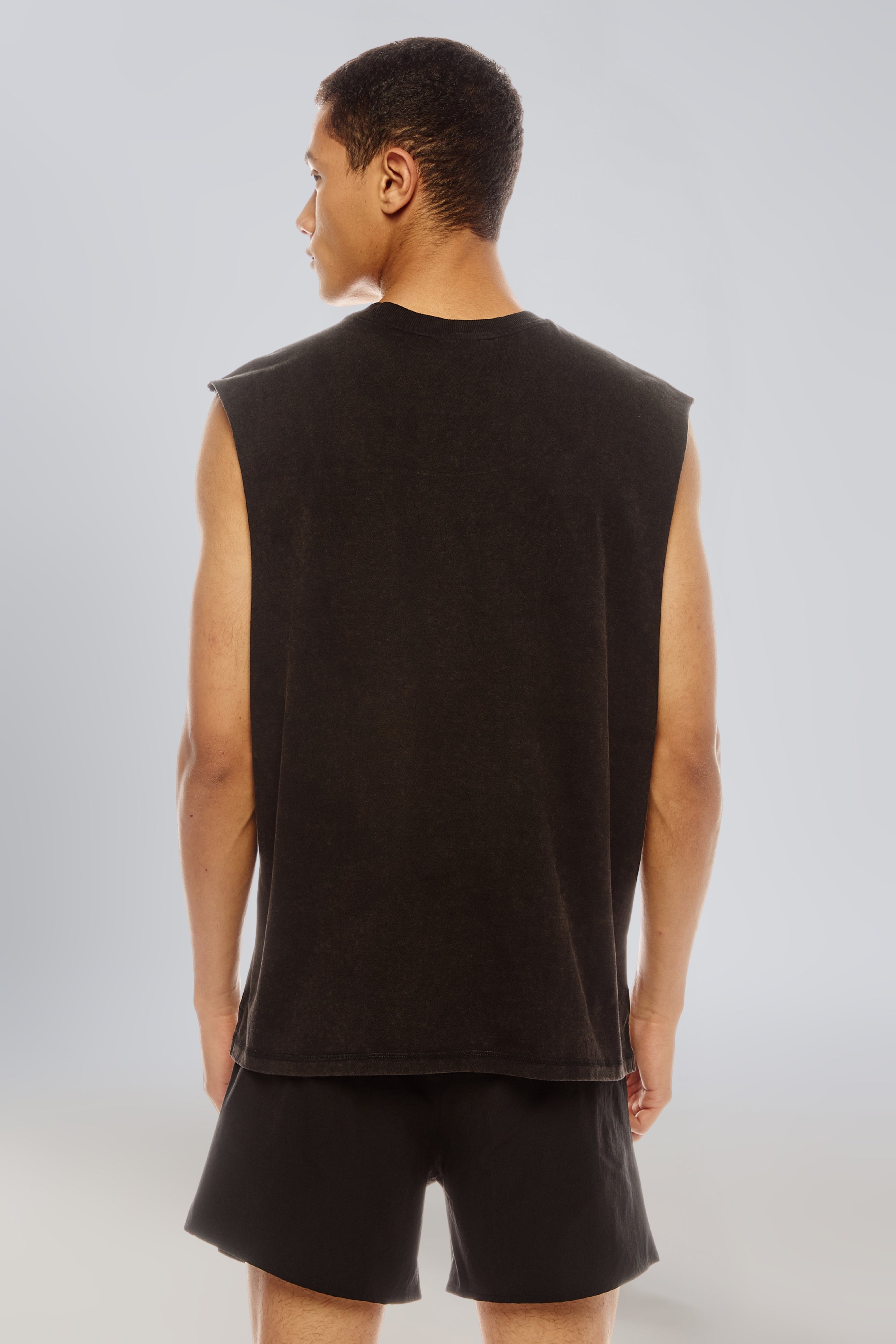Back view of the Carbon Wash tank top styled with black shorts