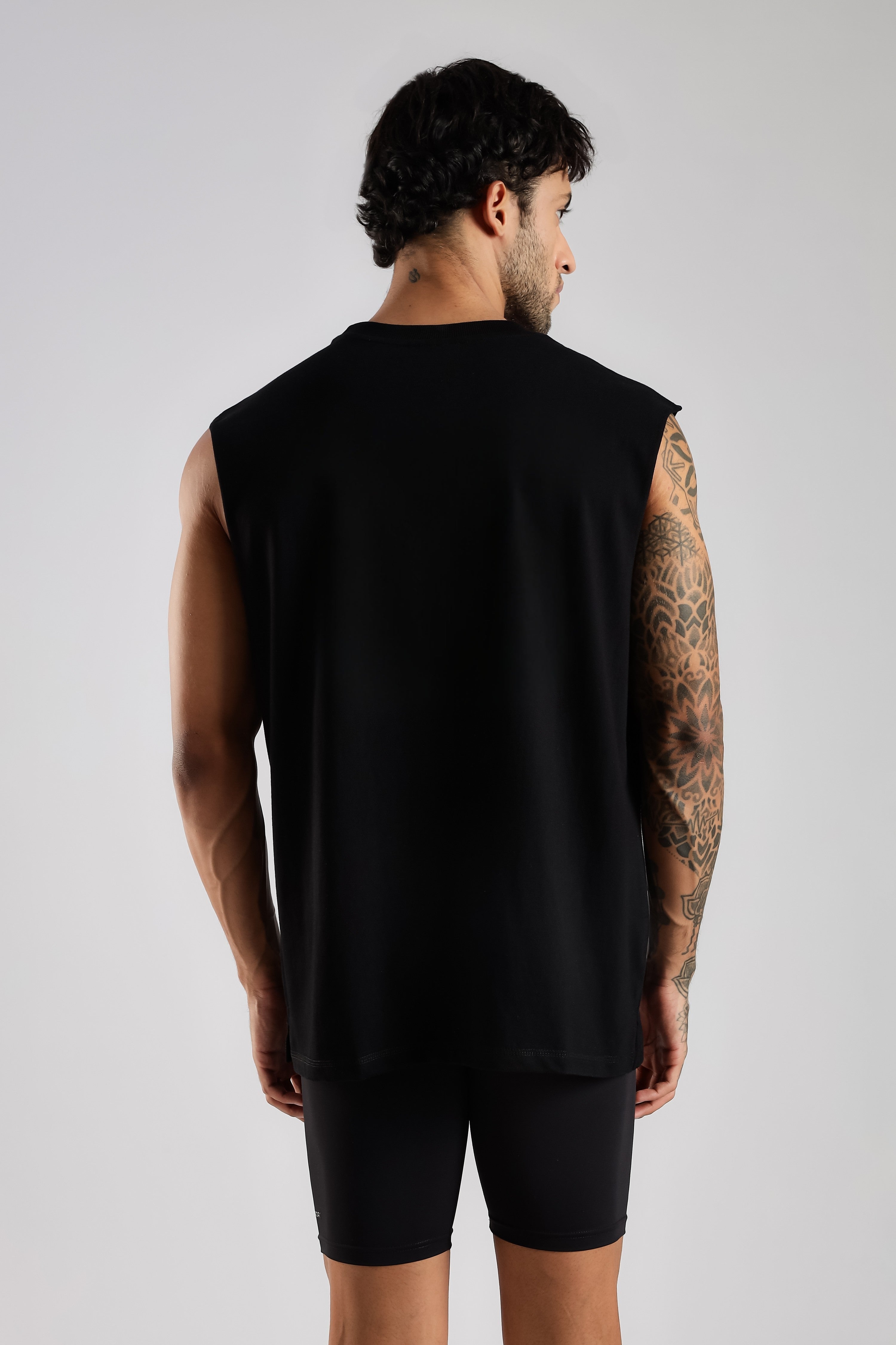 Back view of the model wearing the black Third Society oversized tank top