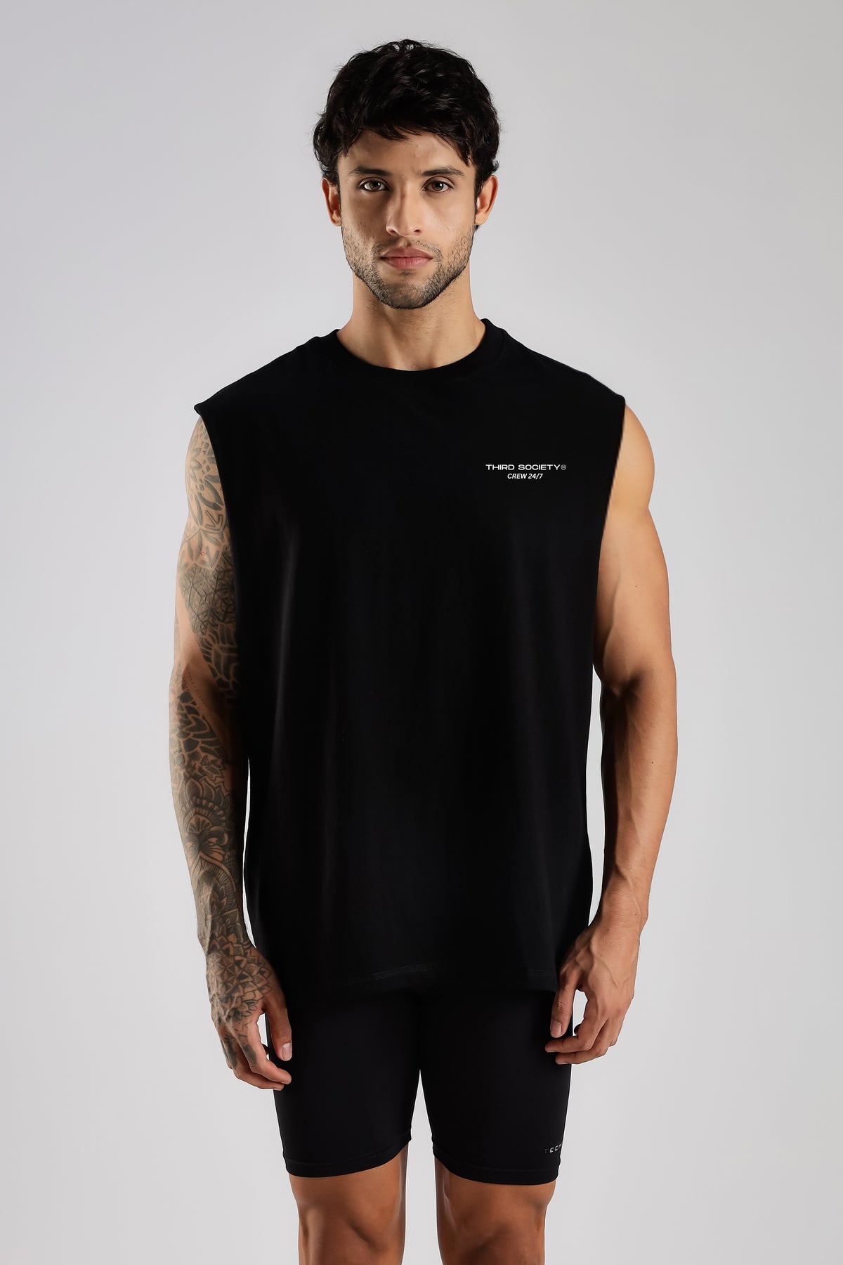 Model wearing the black Third Society tank top with Crew 24/7 chest branding
