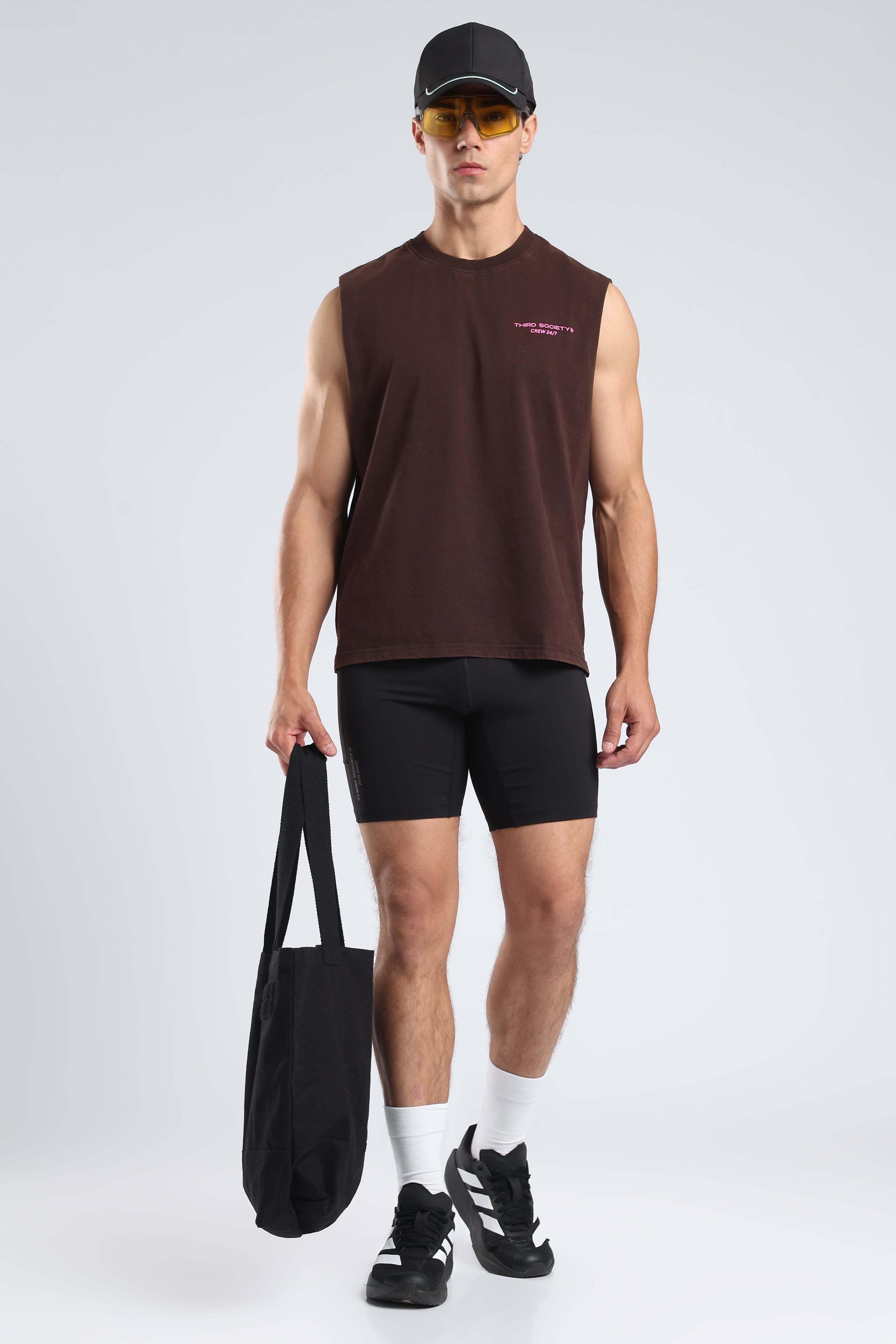 Model wearing the Burnt Umber Wash tank with black shorts, cap and tote bag