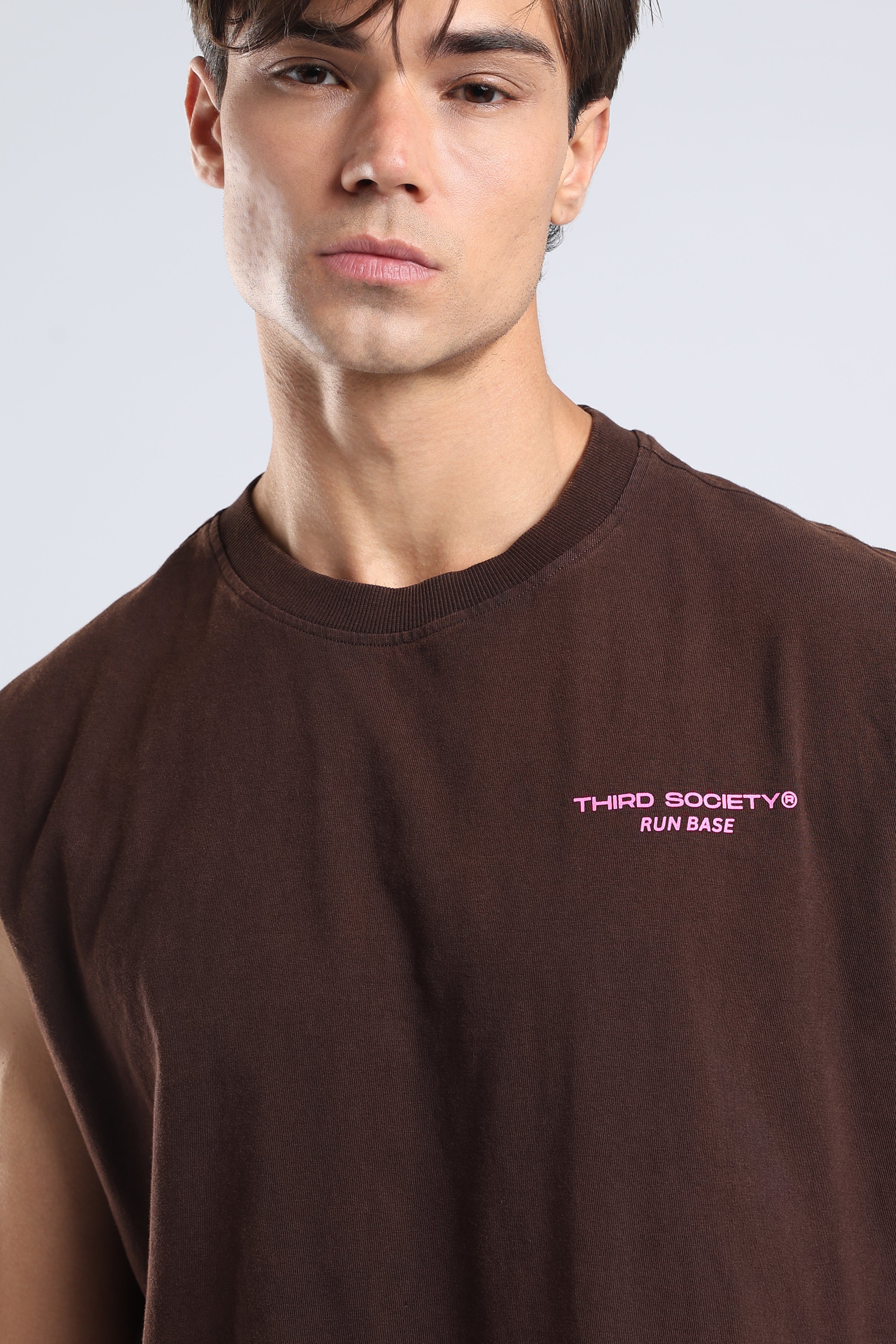 Close-up of the pink Third Society Run Base logo on the brown tank
