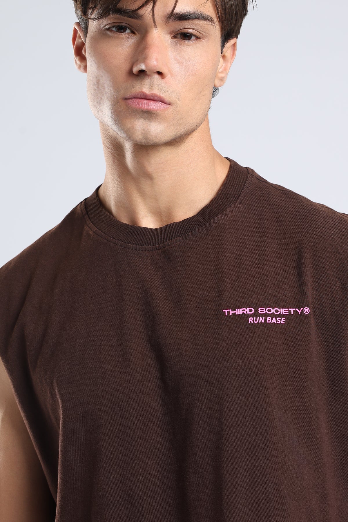 Close-up of the pink Third Society Run Base logo on the brown tank