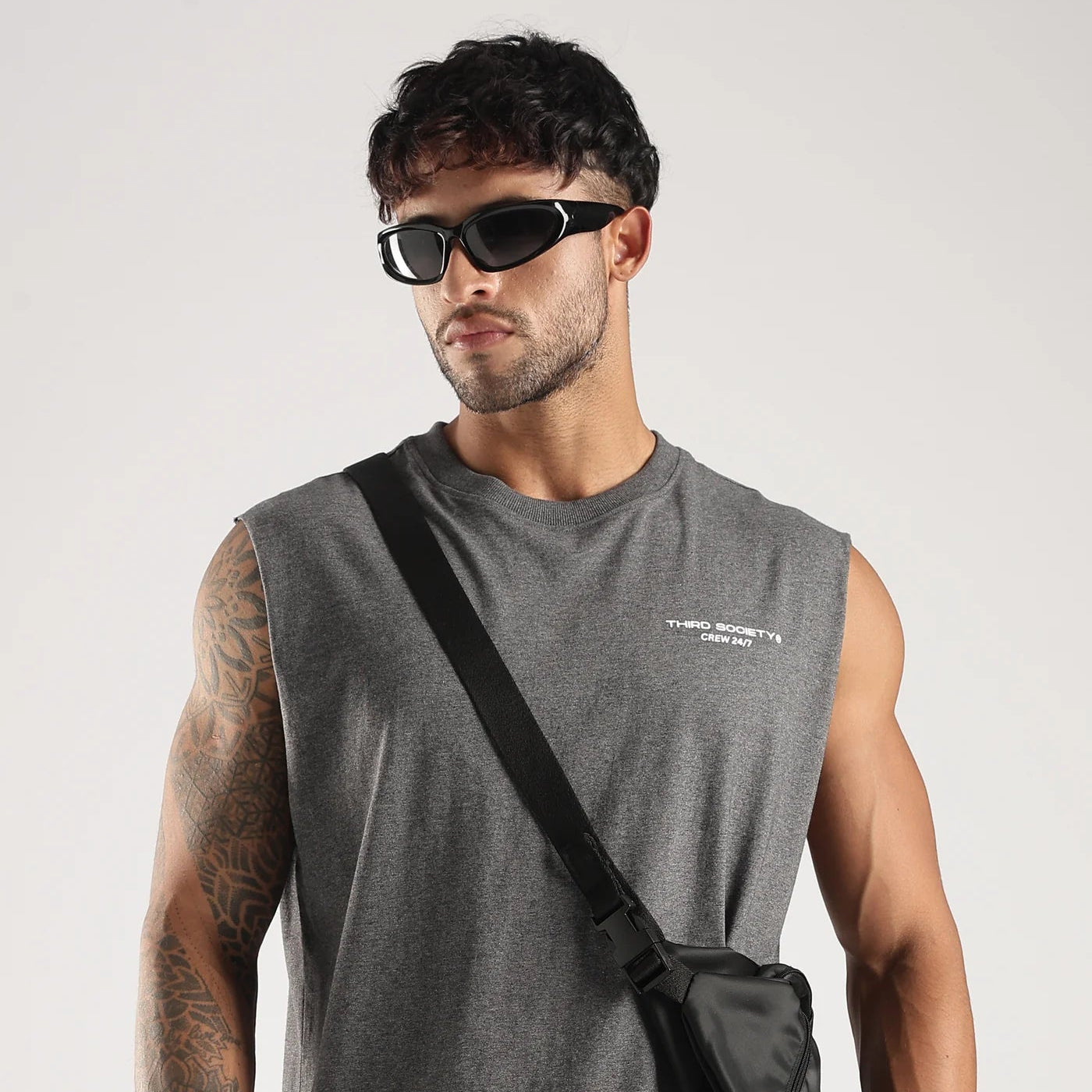 Model wearing the Grey Third Society tank top with Crew 24/7 chest branding