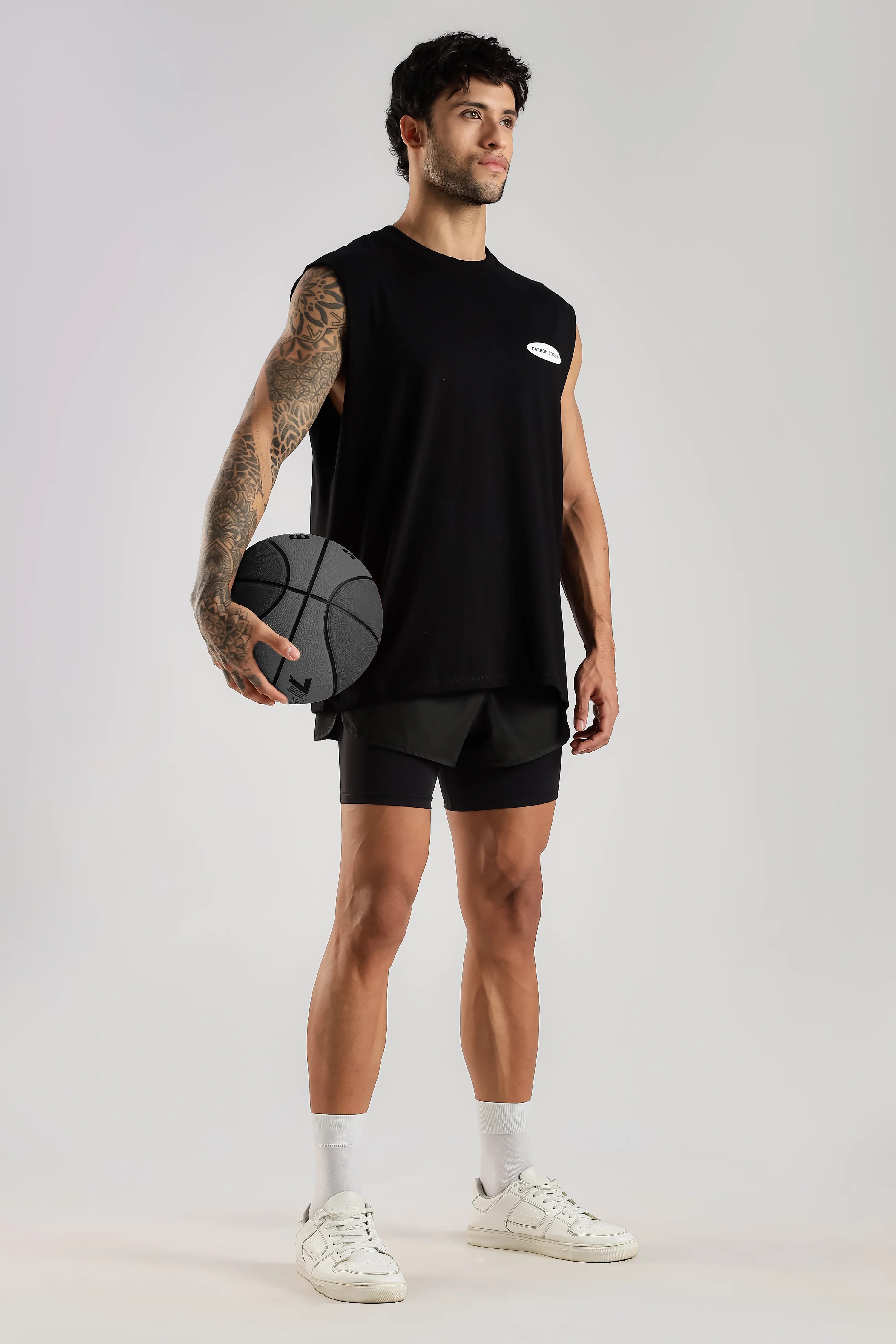 Model wearing the black Training Dept tank top with a basketball, showing the oversized fit