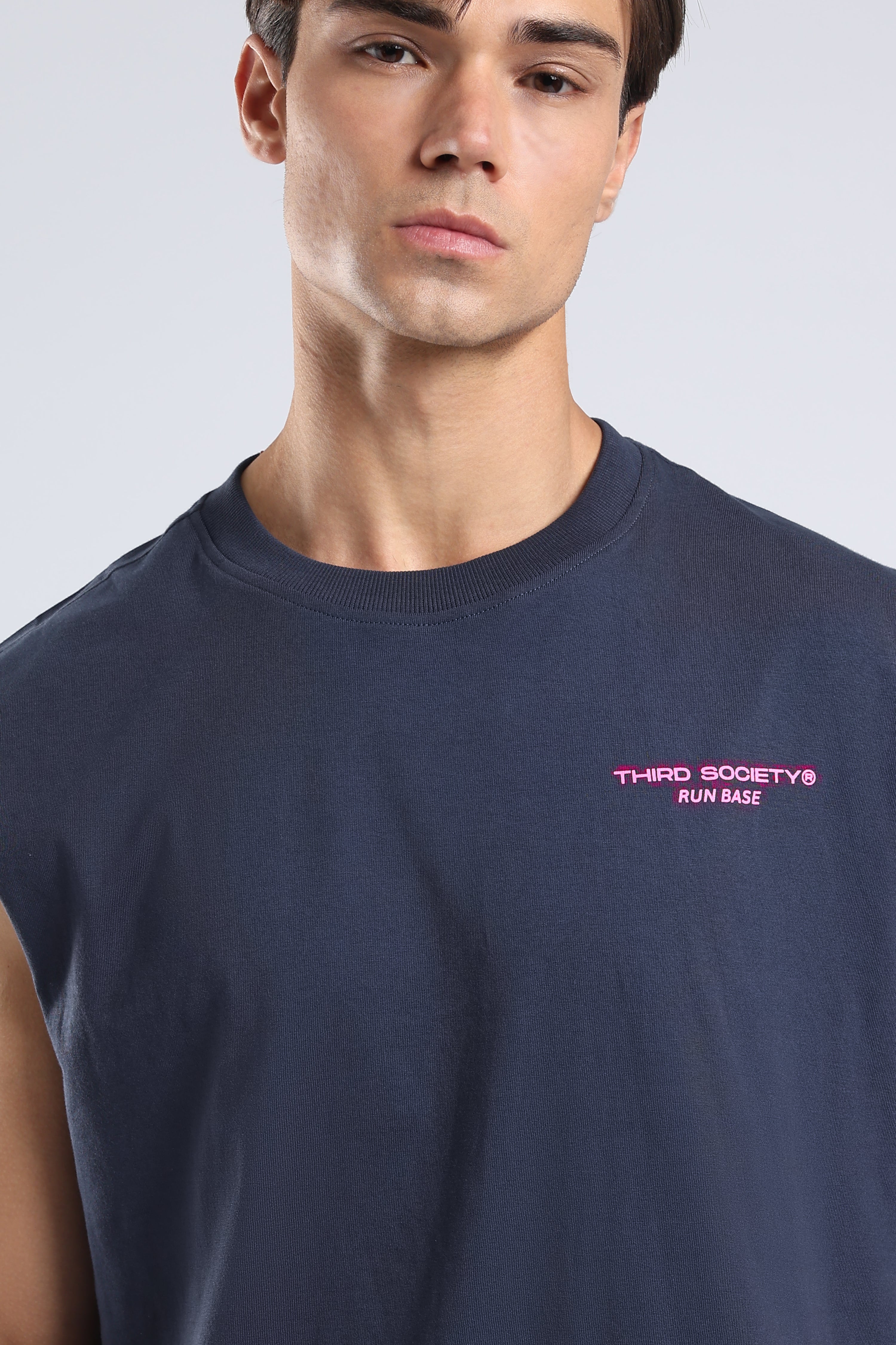 Close-up of the pink Run Base logo on the front of the Iron Blue tank