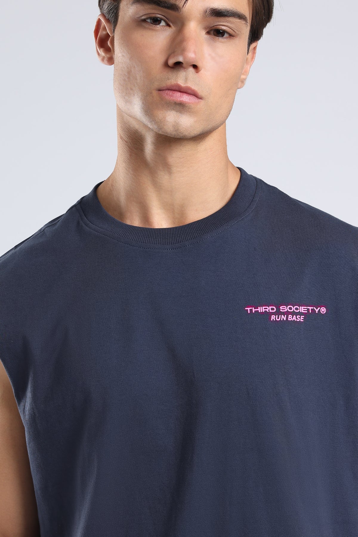 Close-up of the pink Run Base logo on the front of the Iron Blue tank