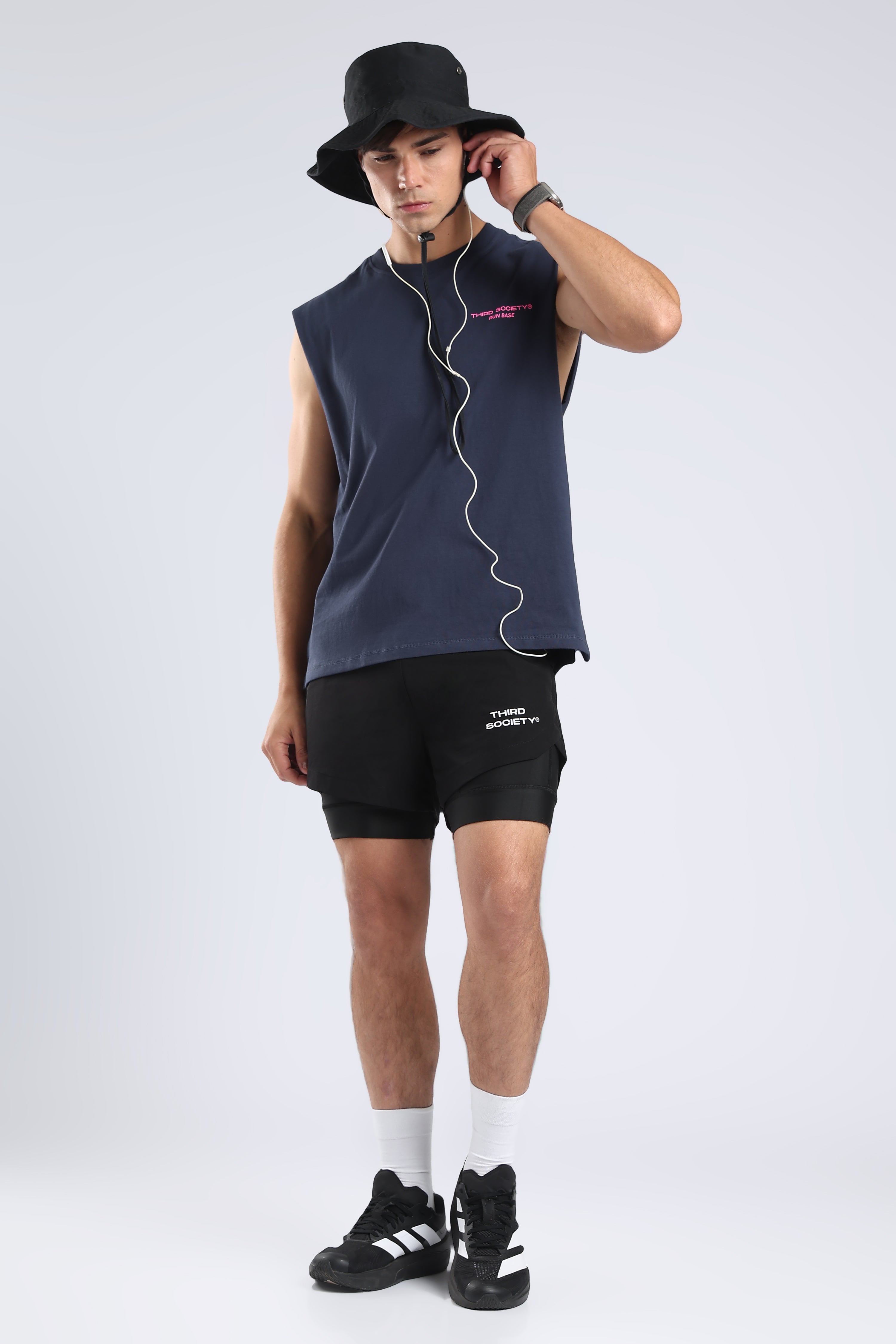 Front view of the Iron Blue tank styled with black shorts and a black bucket hat