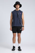 Full front view of the Iron Blue oversized tank top with black shorts and a bucket hat